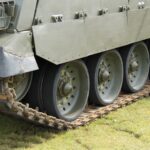 tank tracks on grass, featuring a tank with sheet metal work